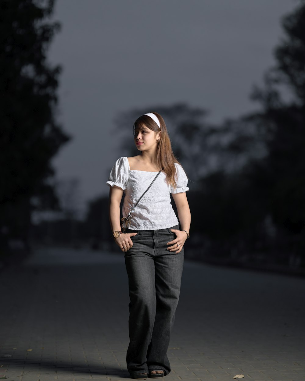una donna in piedi su un marciapiede con le mani sui fianchi