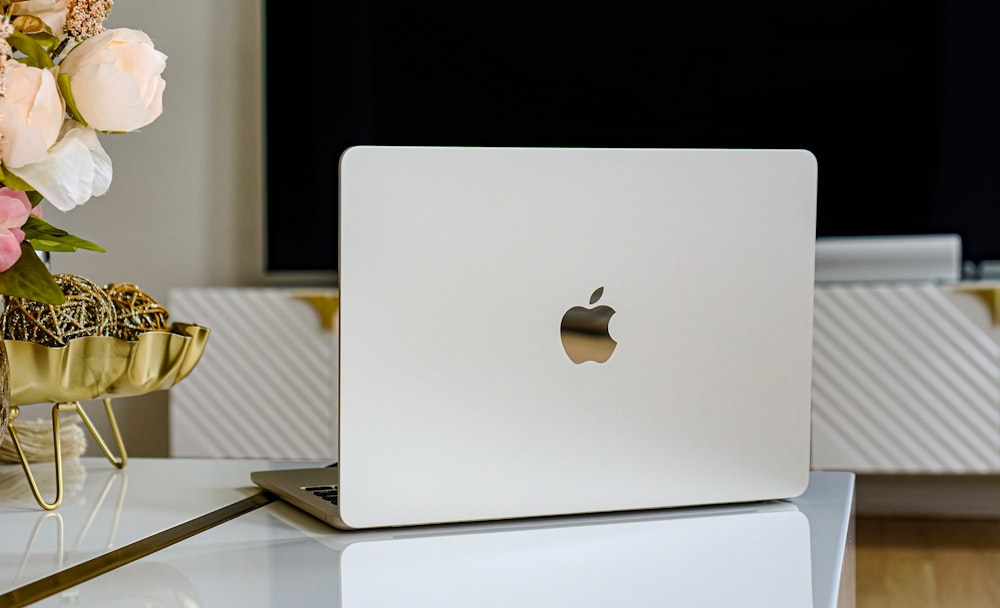 Un ordinateur portable Apple blanc posé sur une table