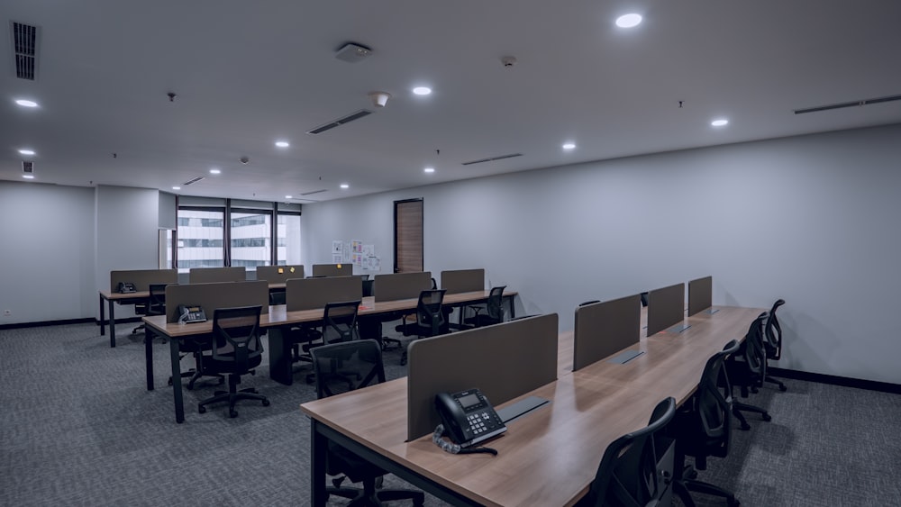 an empty conference room with desks and telephones