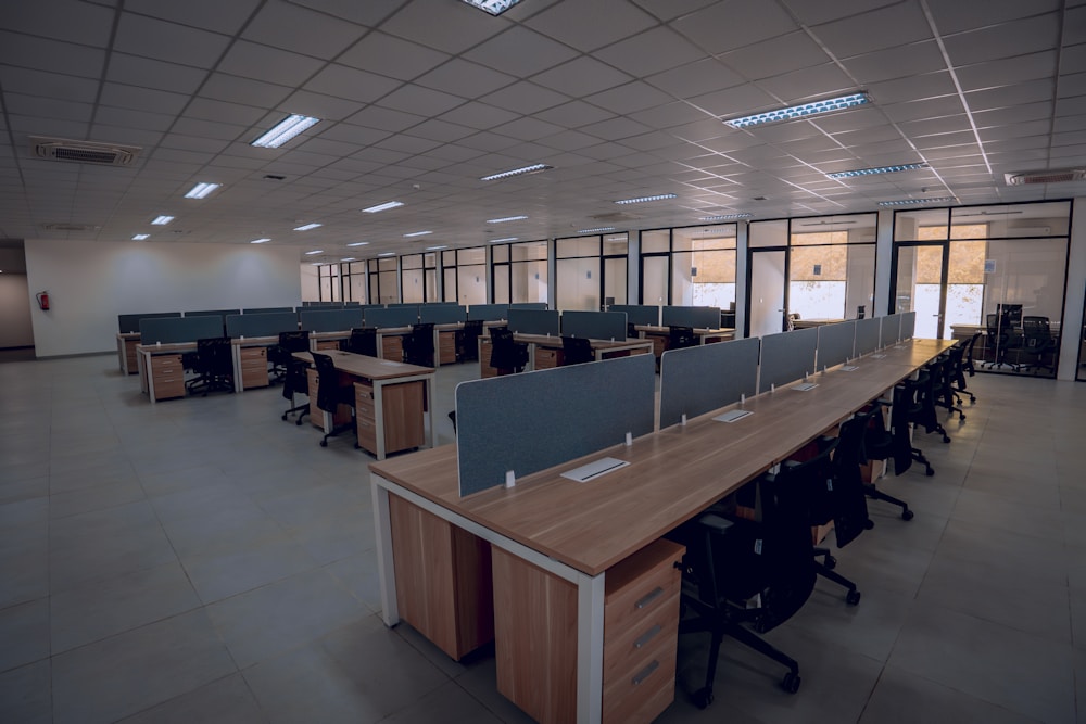 Espace de bureau moderne et lumineux avec rangées de postes de travail vides en open space tertiaire