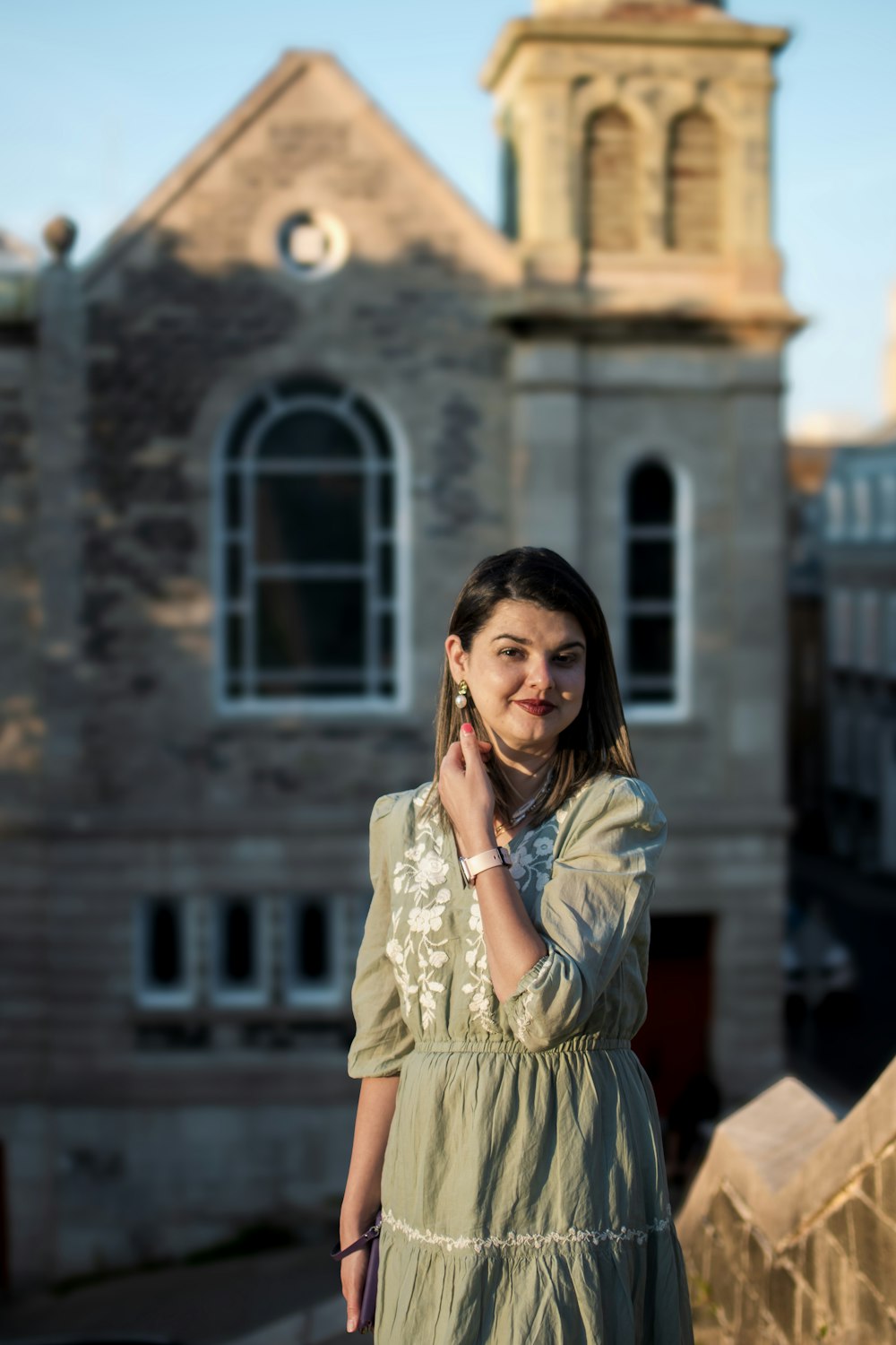 a woman in a dress standing in front of a building