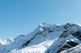 a large mountain covered in snow under a blue sky