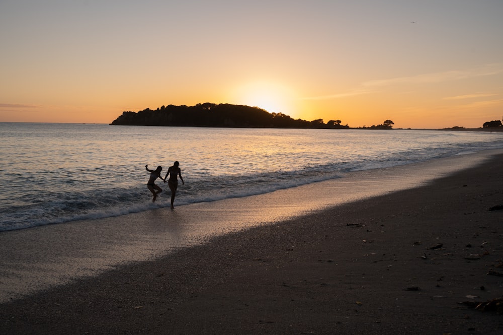 a couple of people that are standing in the sand