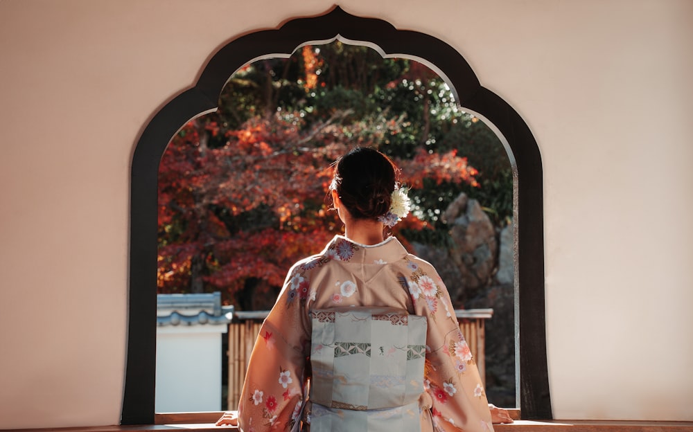 a woman in a kimono looking out a window