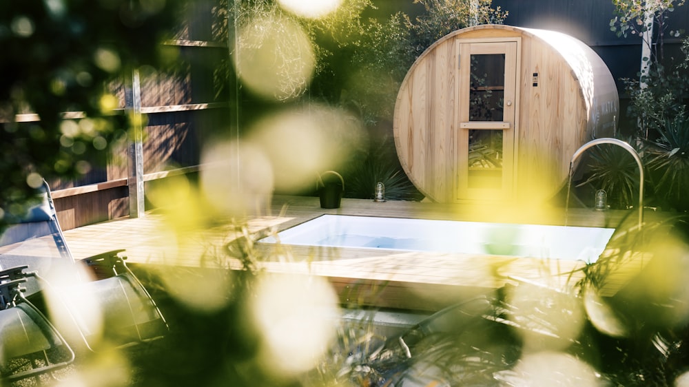 a hot tub in a backyard surrounded by greenery