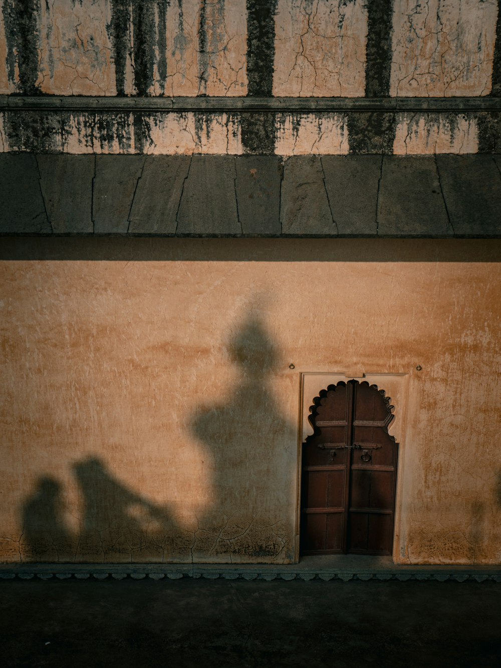 a shadow of a person standing in front of a building