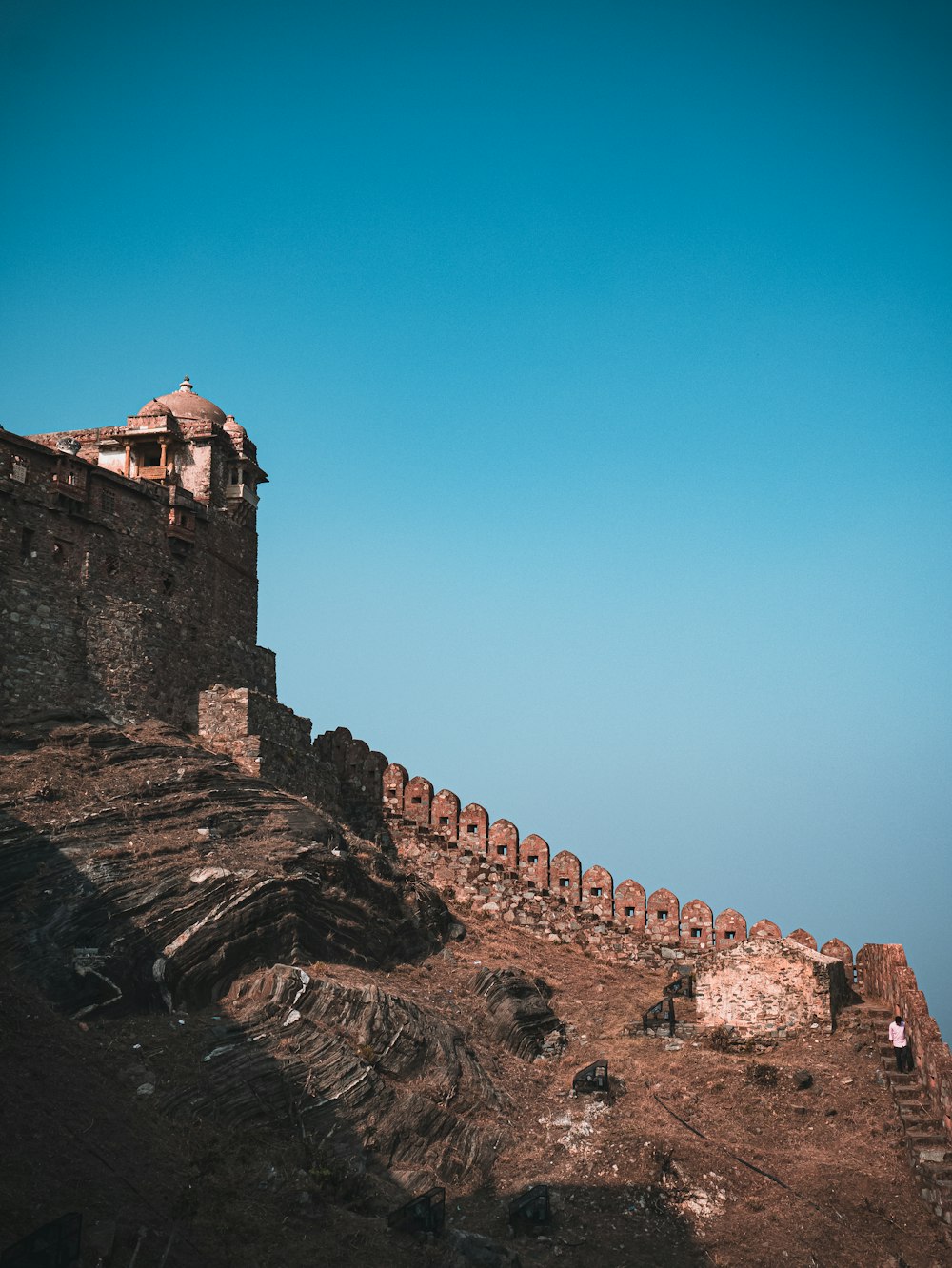 a man standing on top of a mountain next to a castle