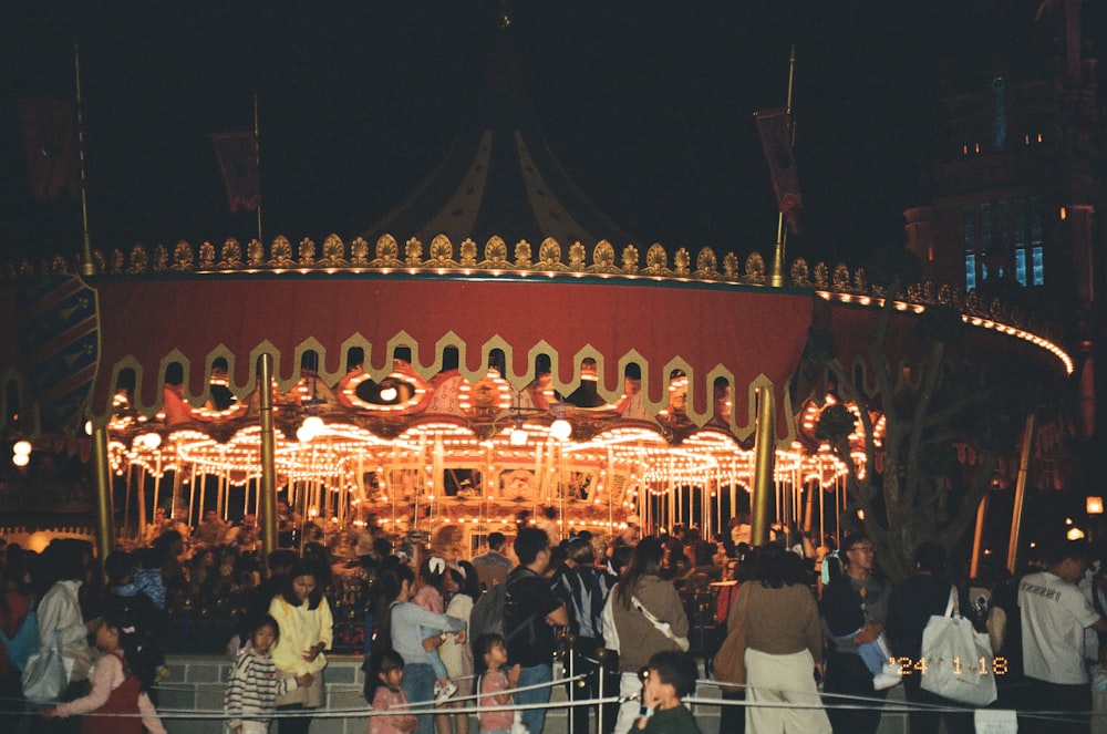 a group of people standing around a merry go round