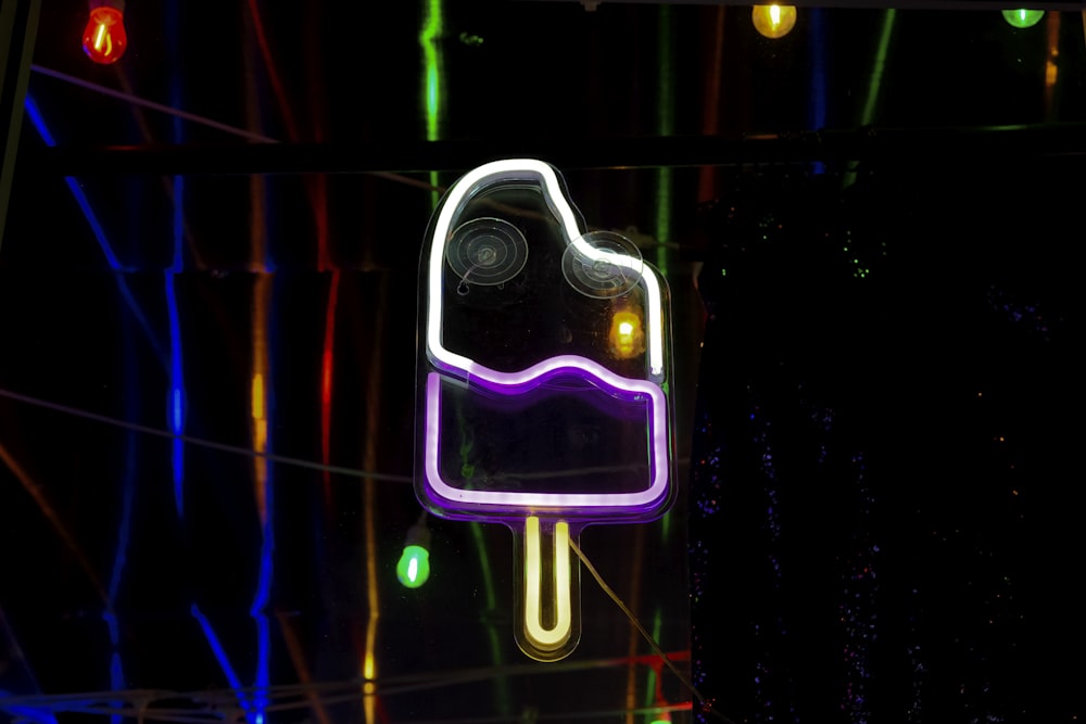 a neon sign with a purple ice cream on it