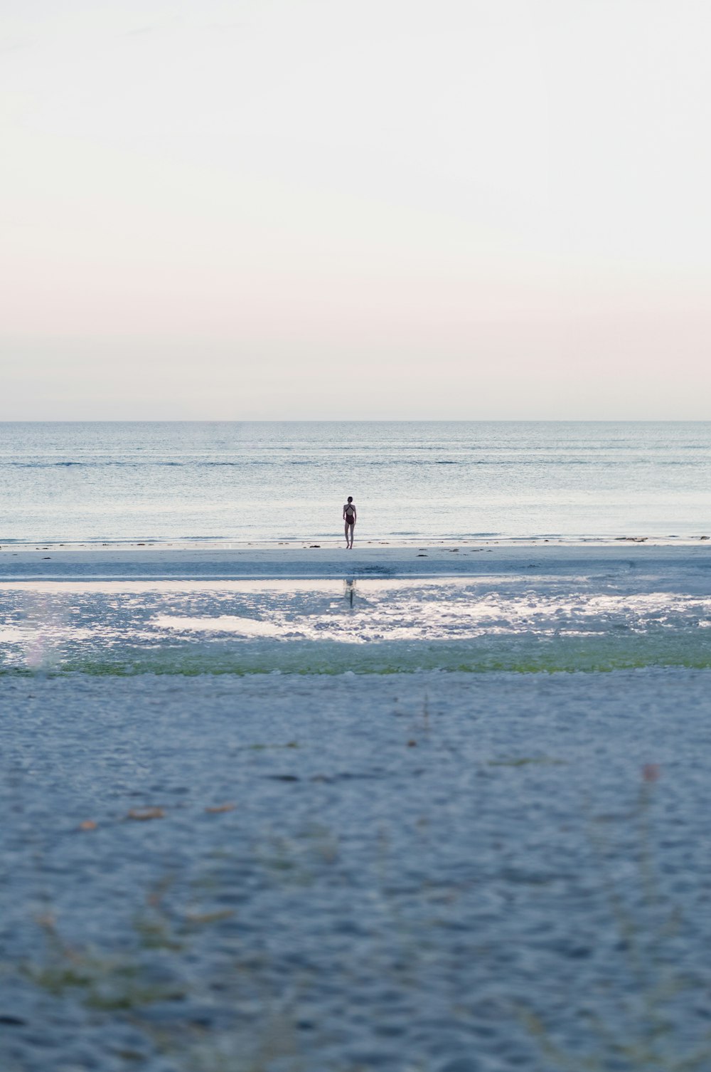 a person standing on a beach near the ocean