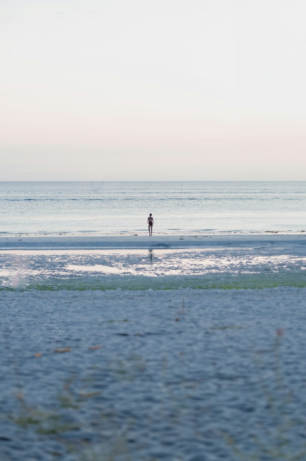 una persona parada en una playa cerca del océano