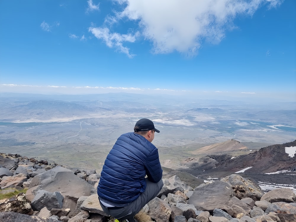 a man sitting on top of a pile of rocks