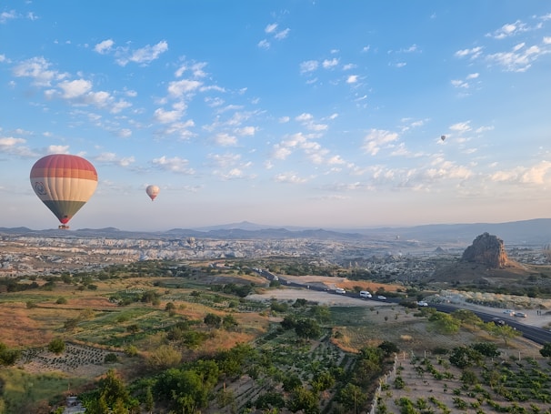 two hot air balloons flying over a city