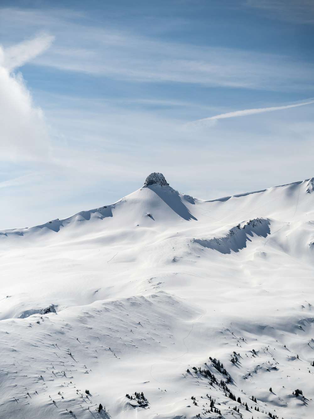 a mountain covered in snow under a blue sky