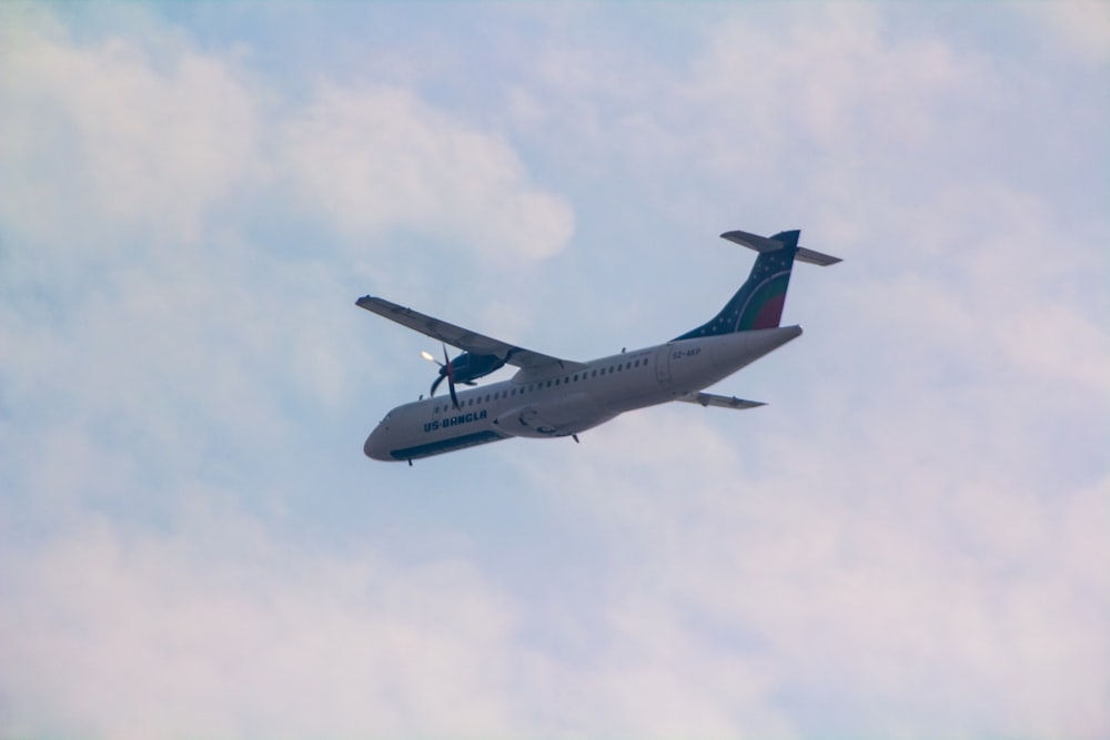 an airplane is flying in the sky on a cloudy day