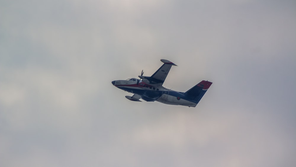 a small airplane flying through a cloudy sky