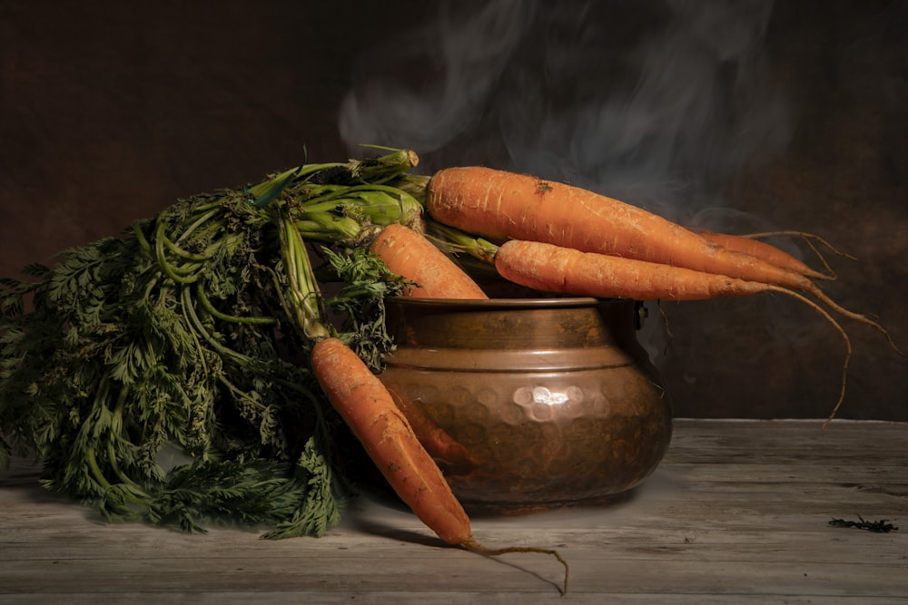 some carrots are sitting in a pot on a table