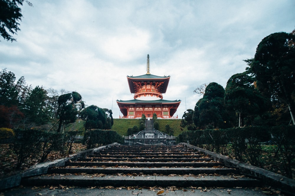 a tall building sitting on top of a lush green hillside