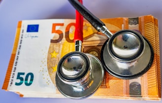 a pair of stethoscopes sitting on top of a 50 euro bill