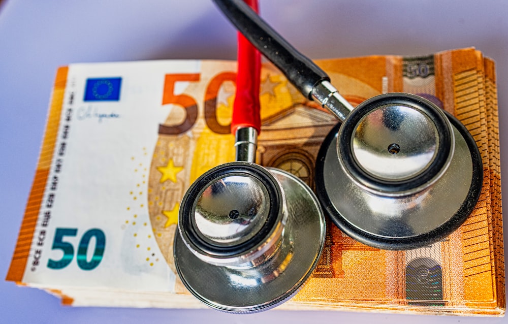 a pair of stethoscopes sitting on top of a 50 euro bill