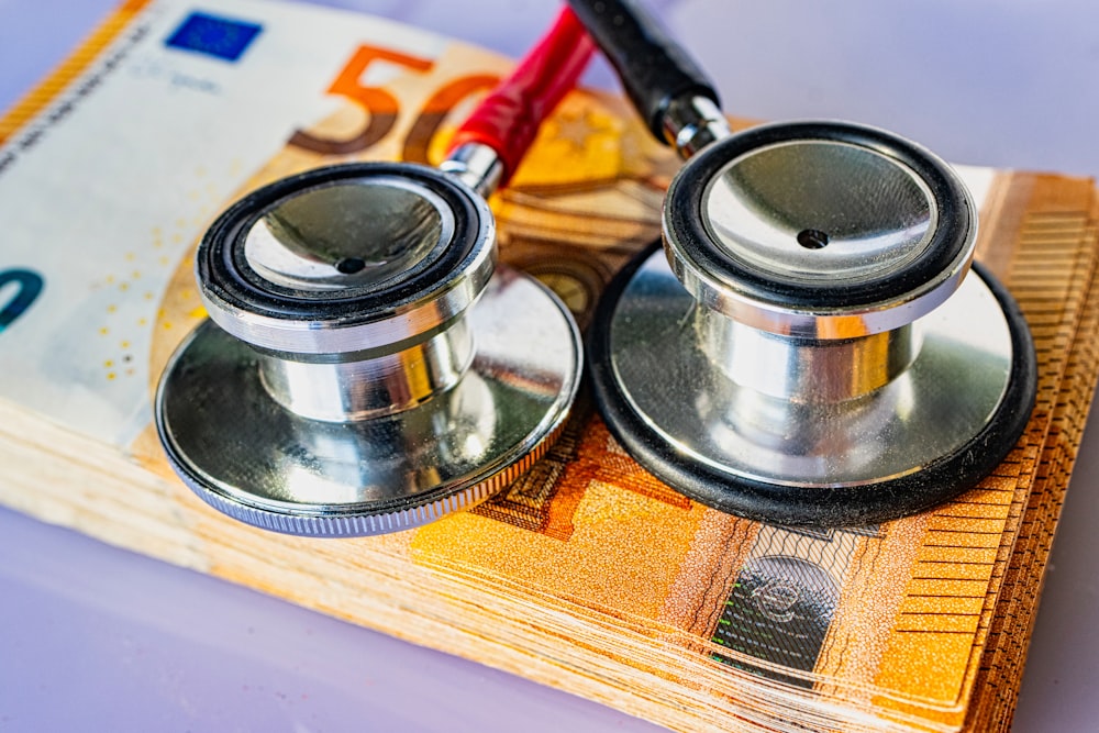 a pair of stethoscopes sitting on top of a pile of money