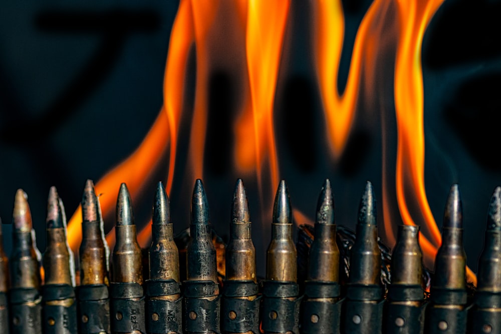 a row of bullet shells with flames in the background
