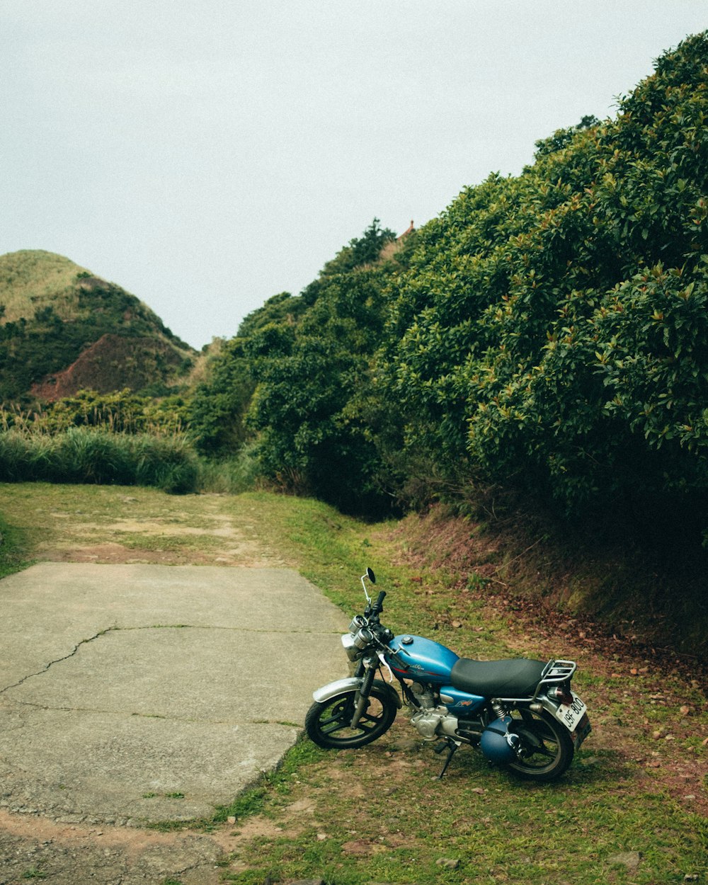 una motocicletta blu parcheggiata sul ciglio di una strada
