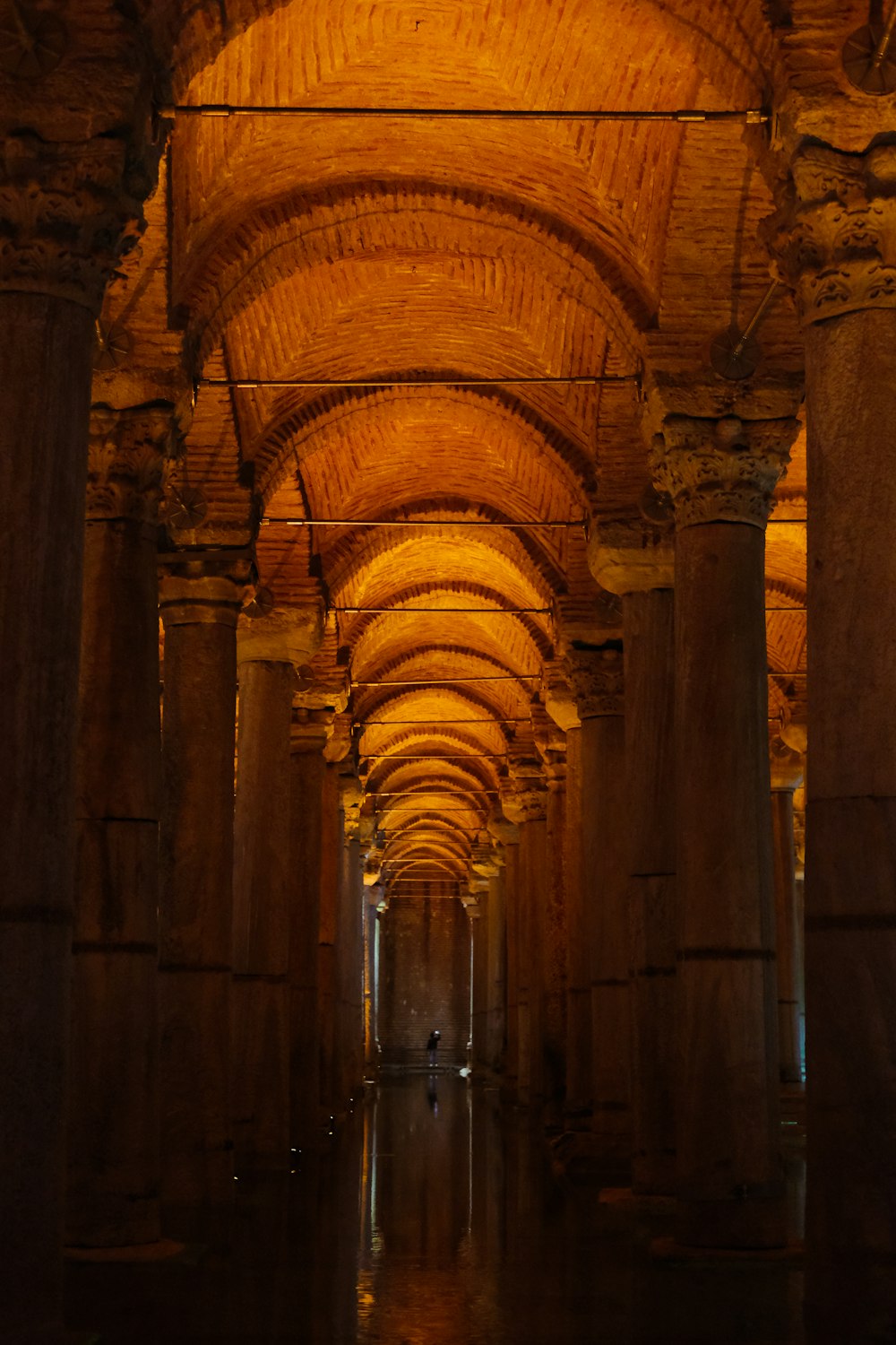 a long hallway with columns and a clock on the wall