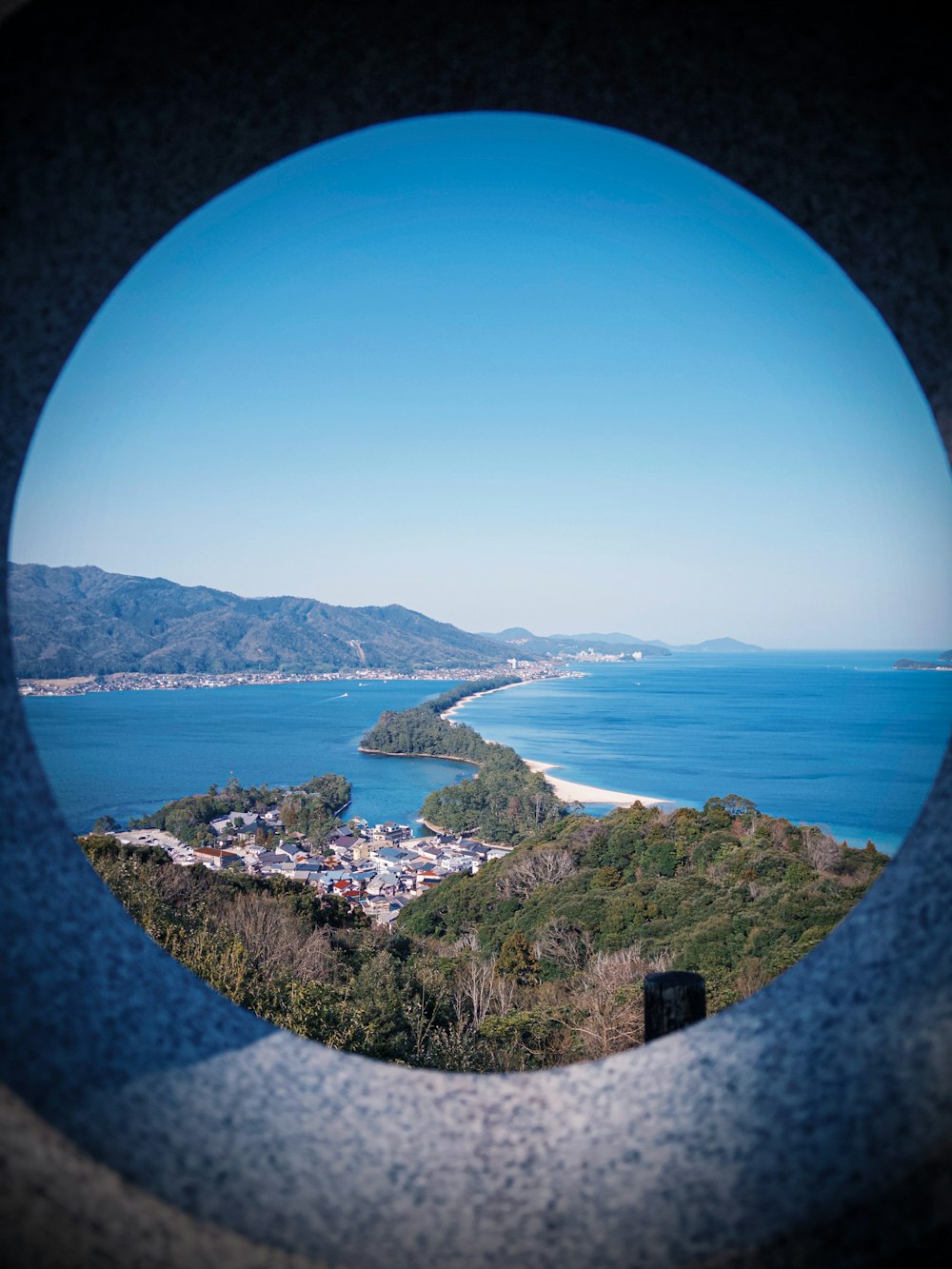 a view of a body of water through a hole in a wall