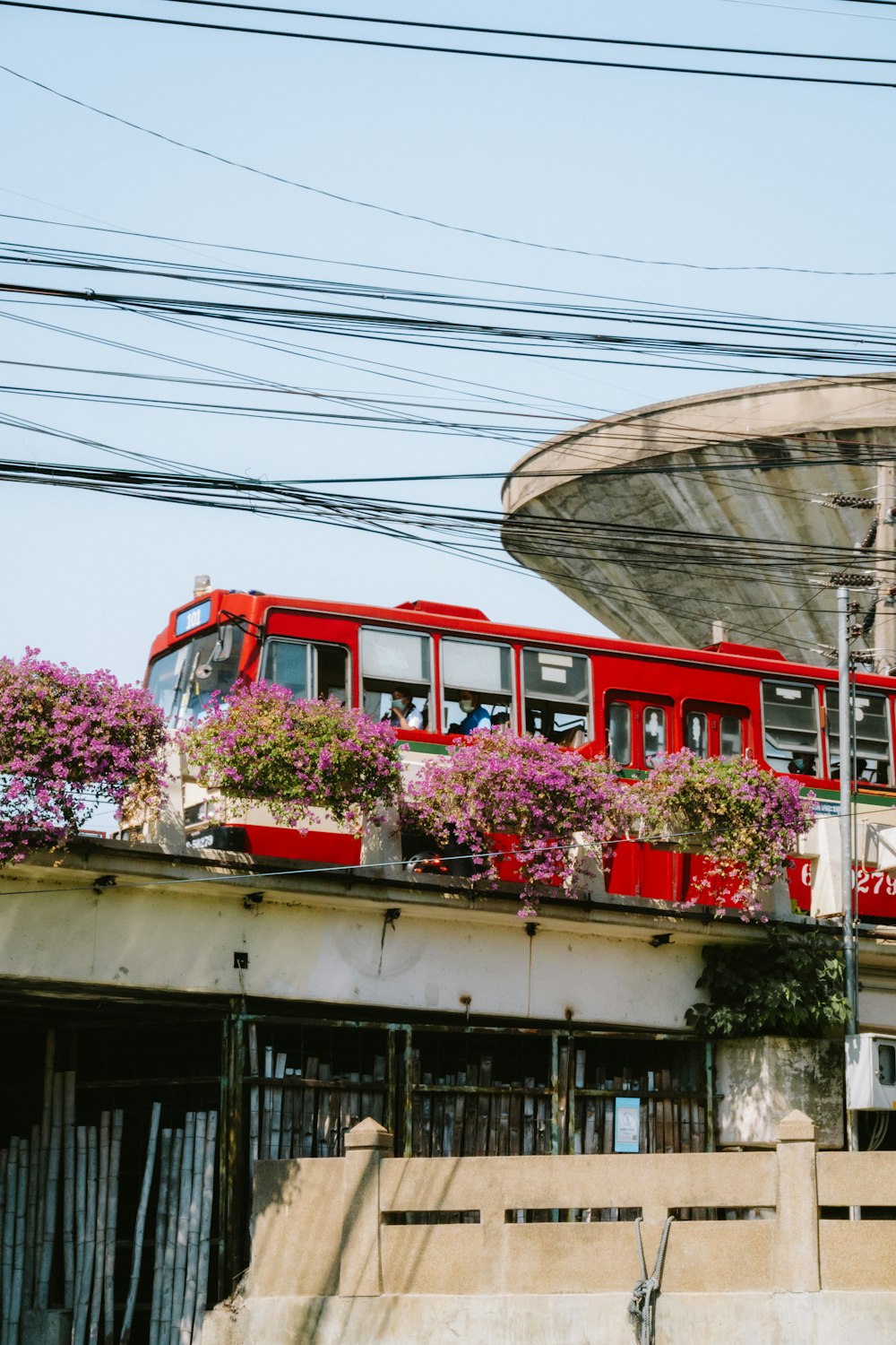 a red bus driving down a street next to a tall building