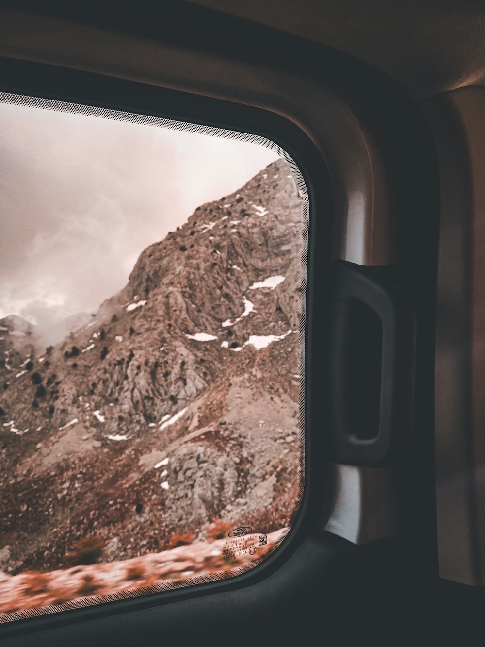 a mountain seen through a window of a vehicle