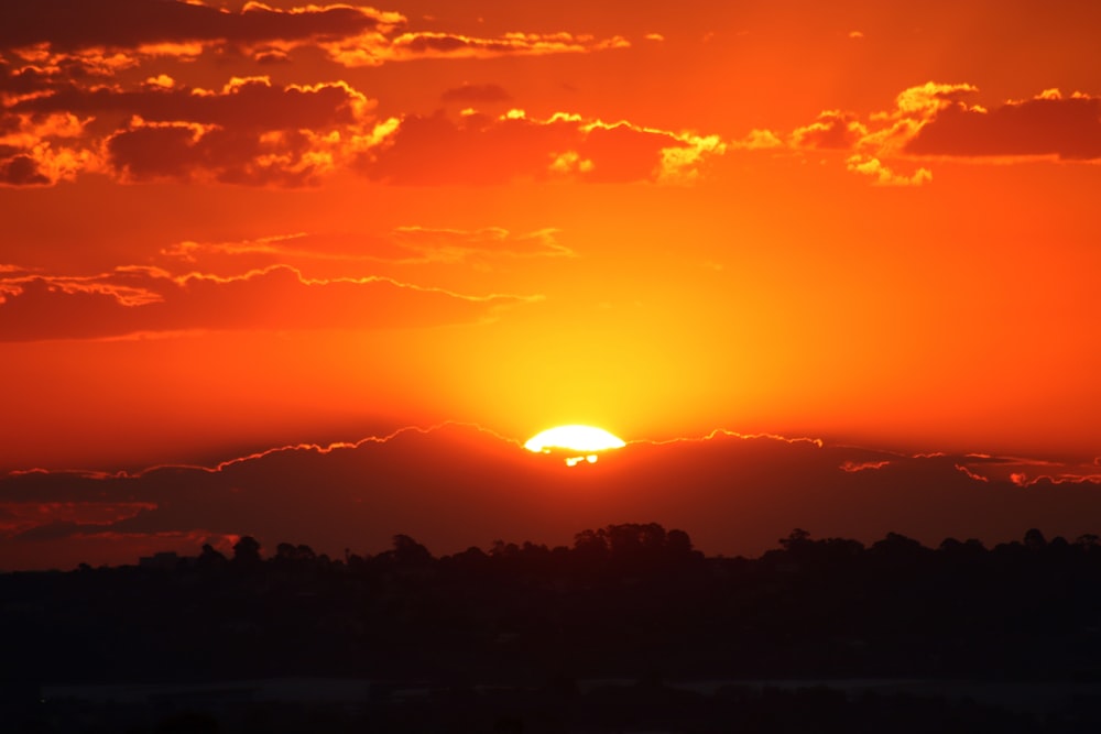 the sun is setting over a mountain range