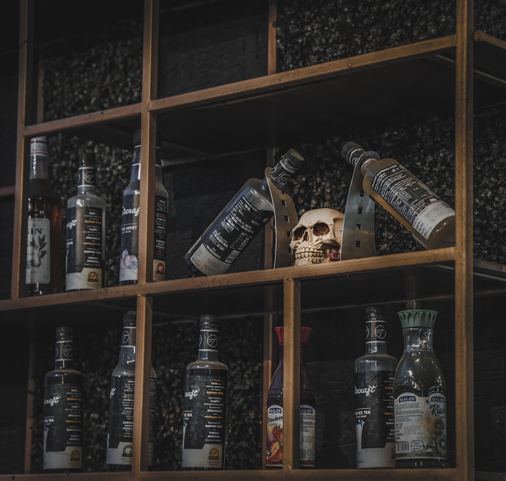 a wooden shelf filled with bottles and a skull