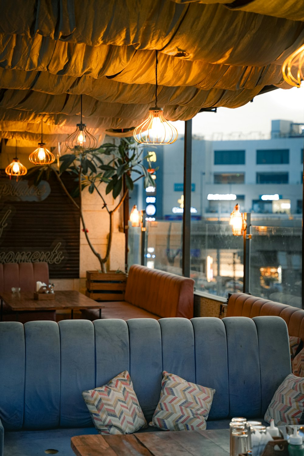 a room with couches, tables and a large window