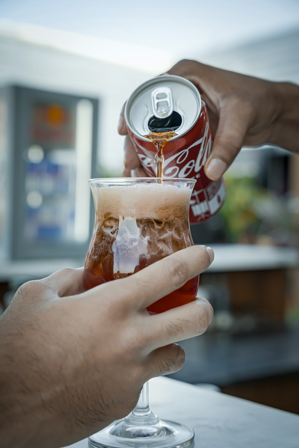 a person is pouring a drink into a glass