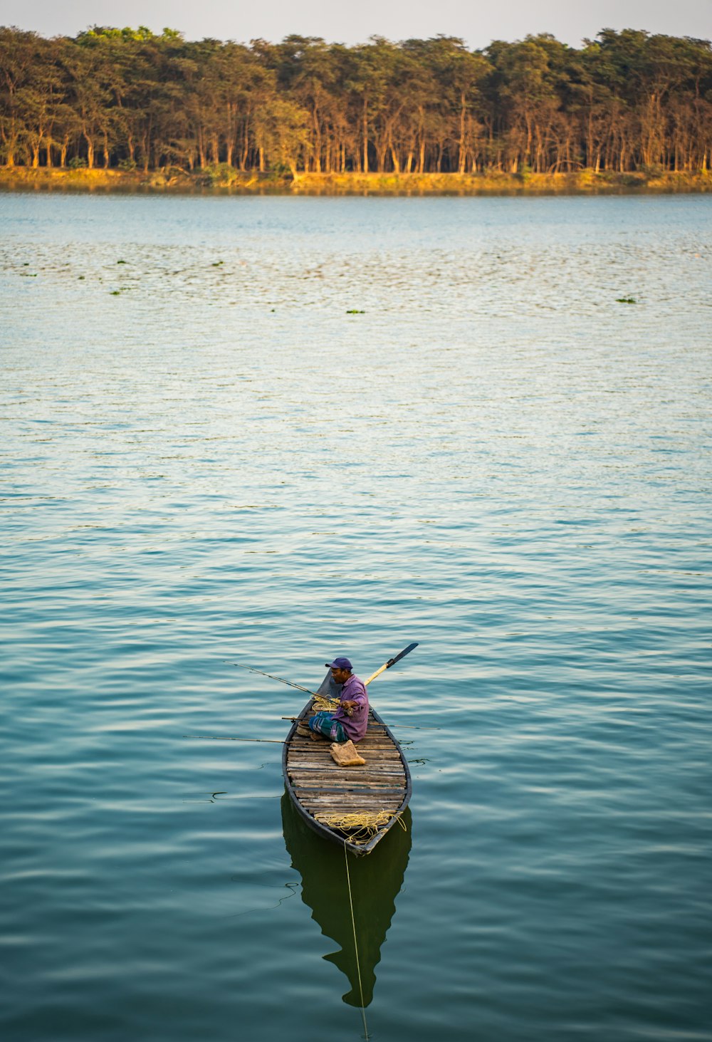 a person in a small boat on a lake