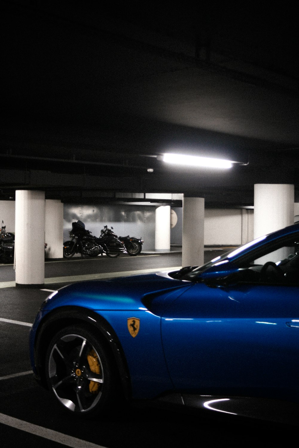 a blue sports car parked in a parking garage
