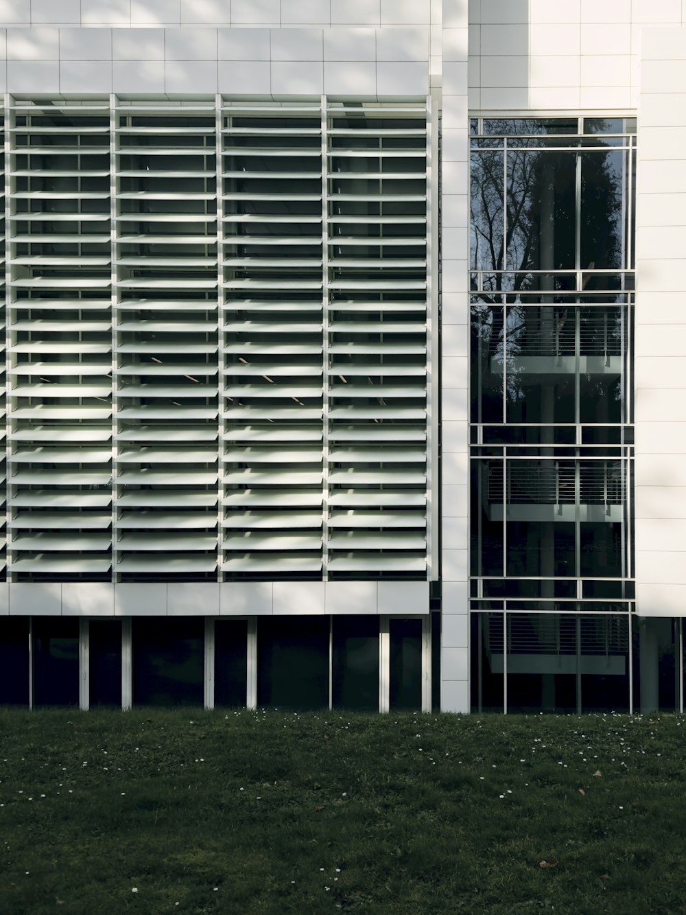 a white building with a grassy lawn in front of it