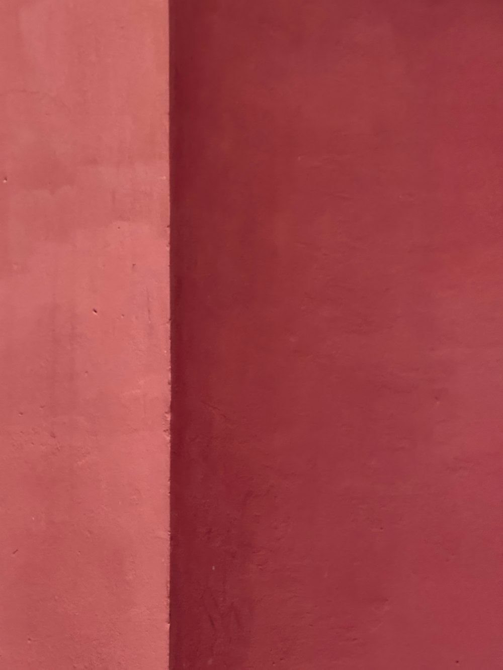 a man sitting on a bench in front of a red wall