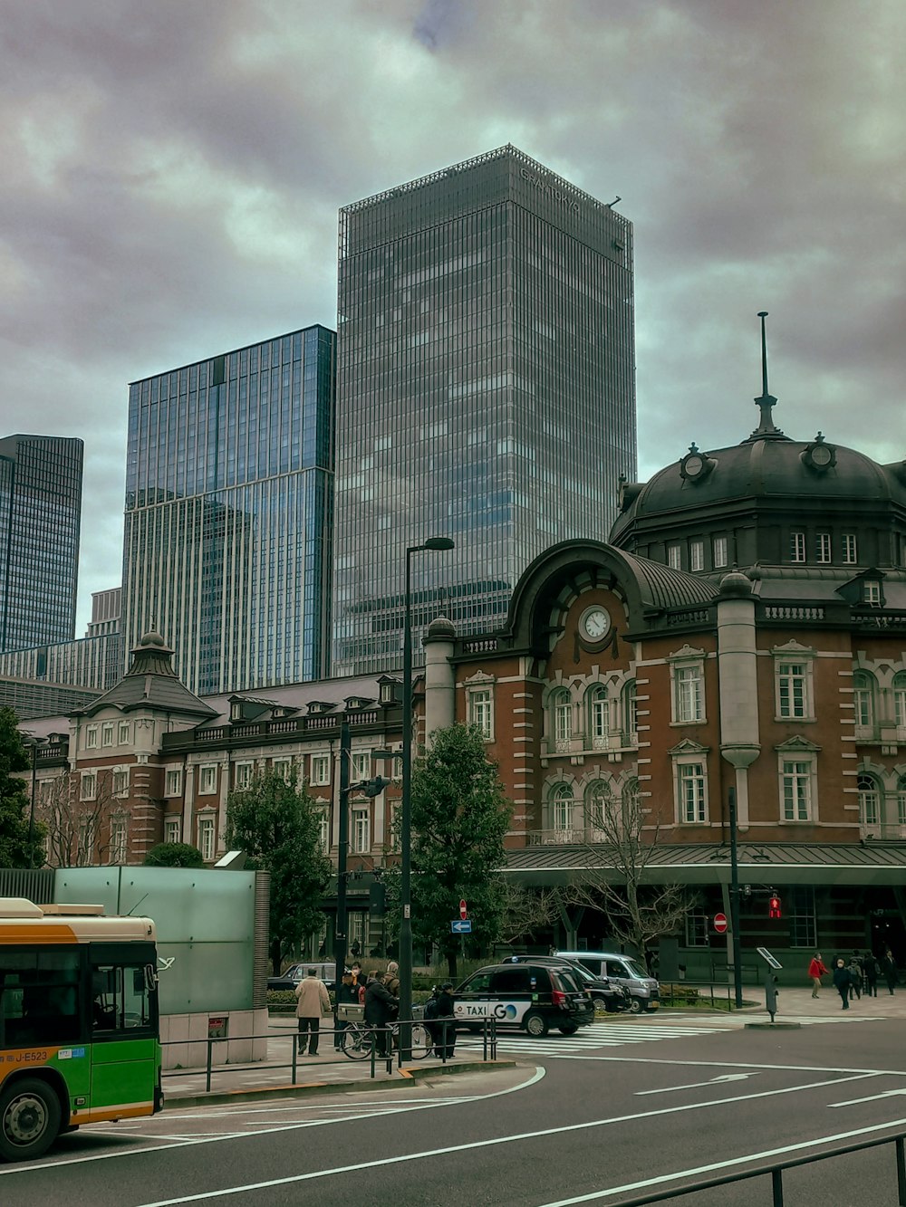 a bus driving down a street next to tall buildings