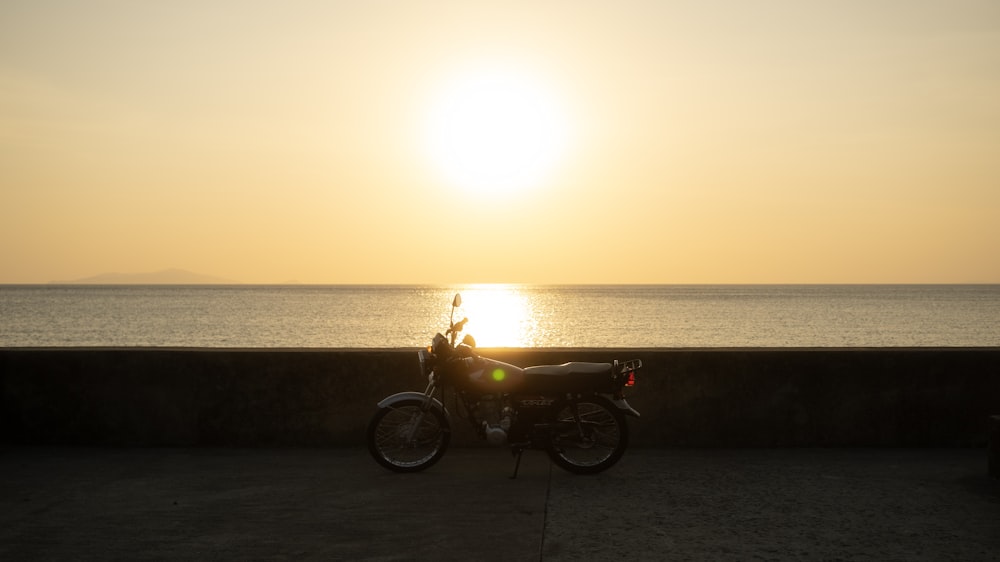 a motorcycle parked on the side of a road near the ocean