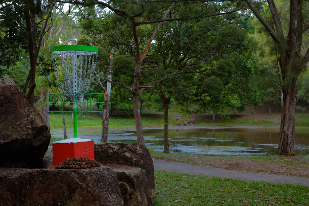 a frisbee golf goal in a park with a lake in the background