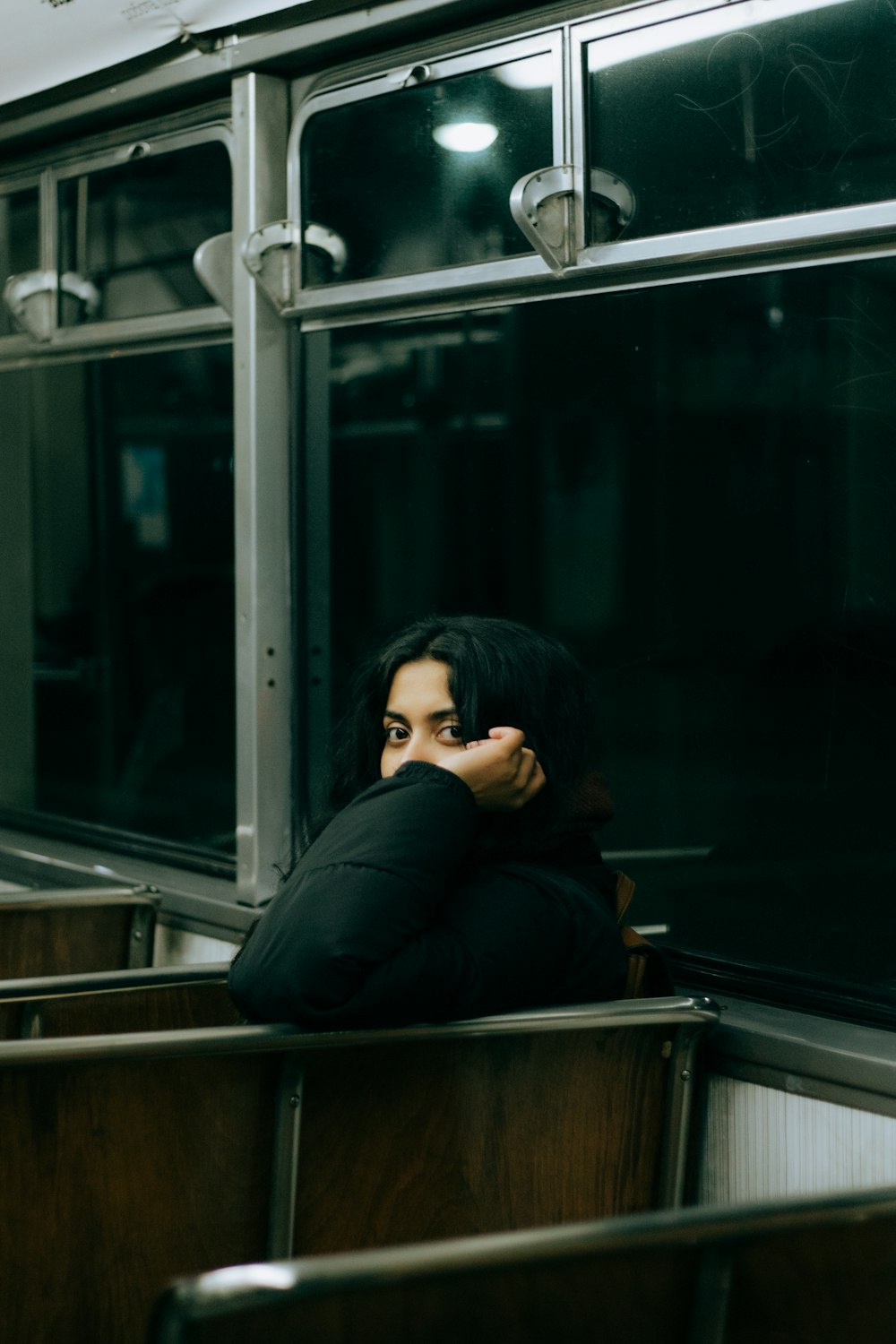 a woman sitting on a train talking on a cell phone