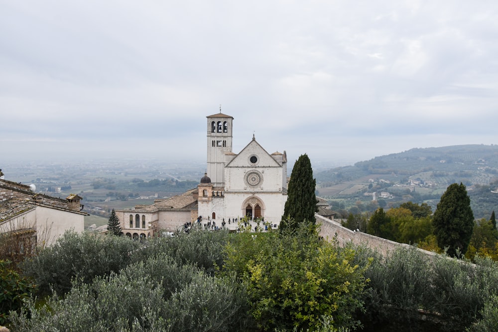 a church with a clock tower on top of a hill