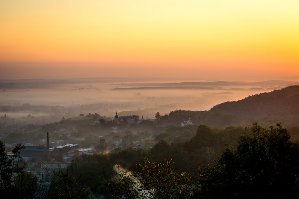 the sun is setting over a city in the distance