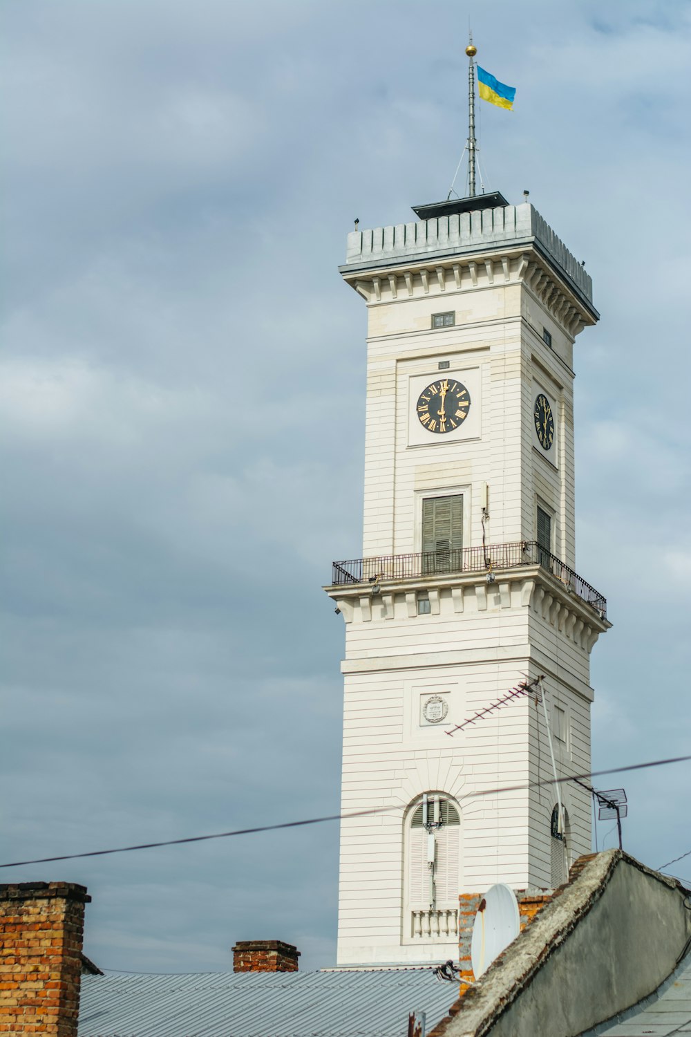 uma alta torre de relógio branco com uma bandeira no topo