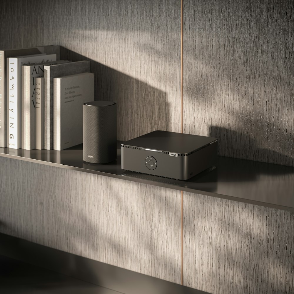 a shelf with books and a speaker on it