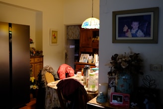 a living room with a table and a refrigerator