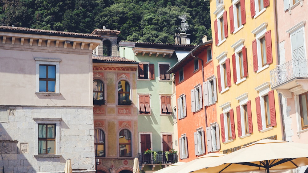 a row of colorful buildings with umbrellas in front of them