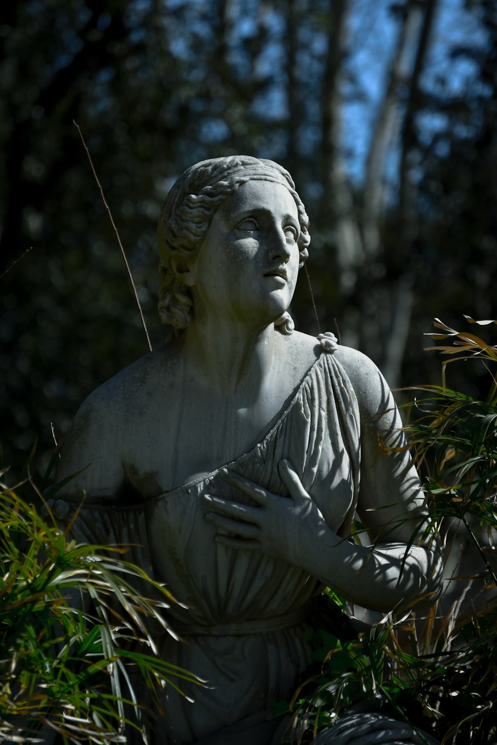 a statue of a woman in a garden
